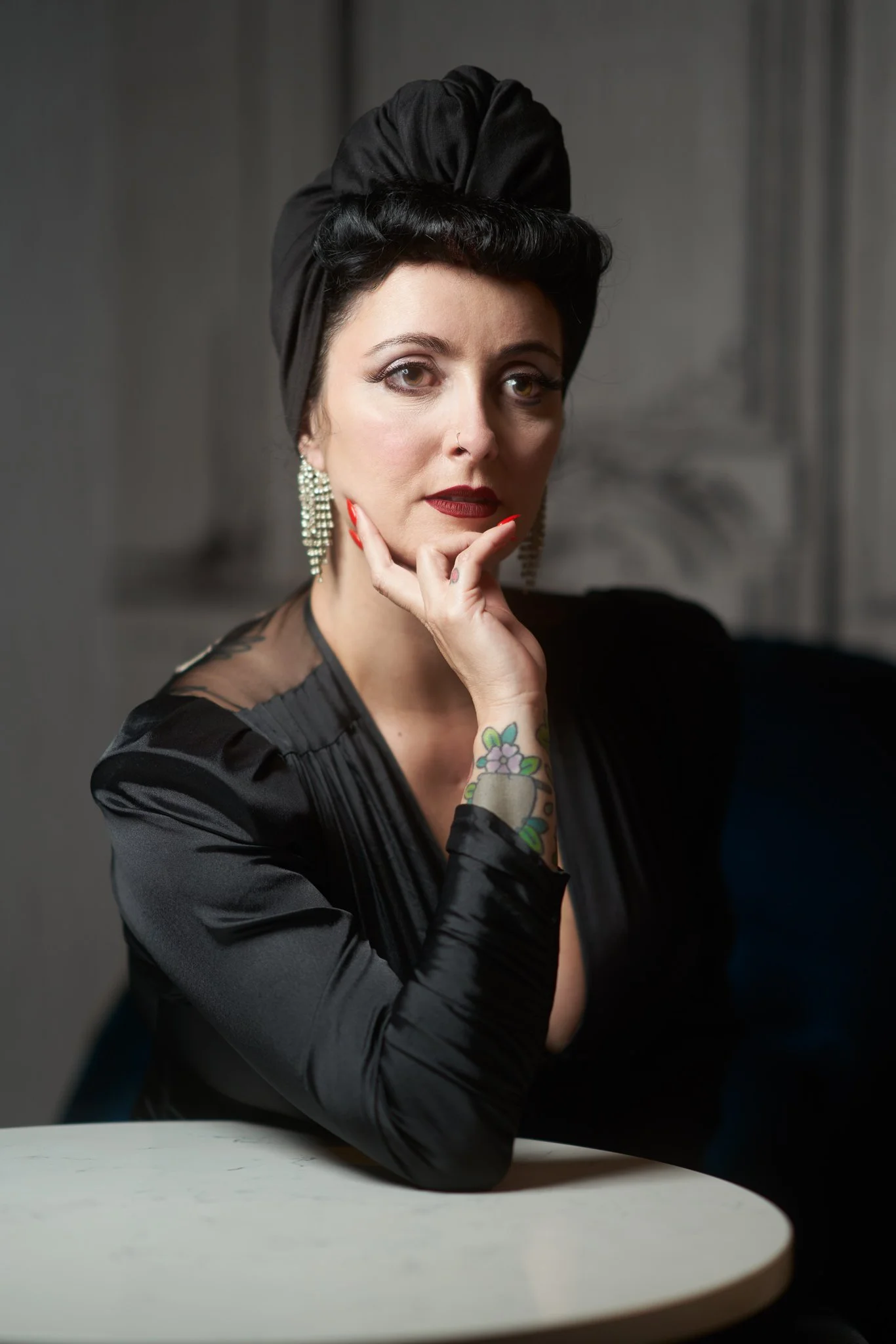 Viv in a black turban resting her chin on her hand