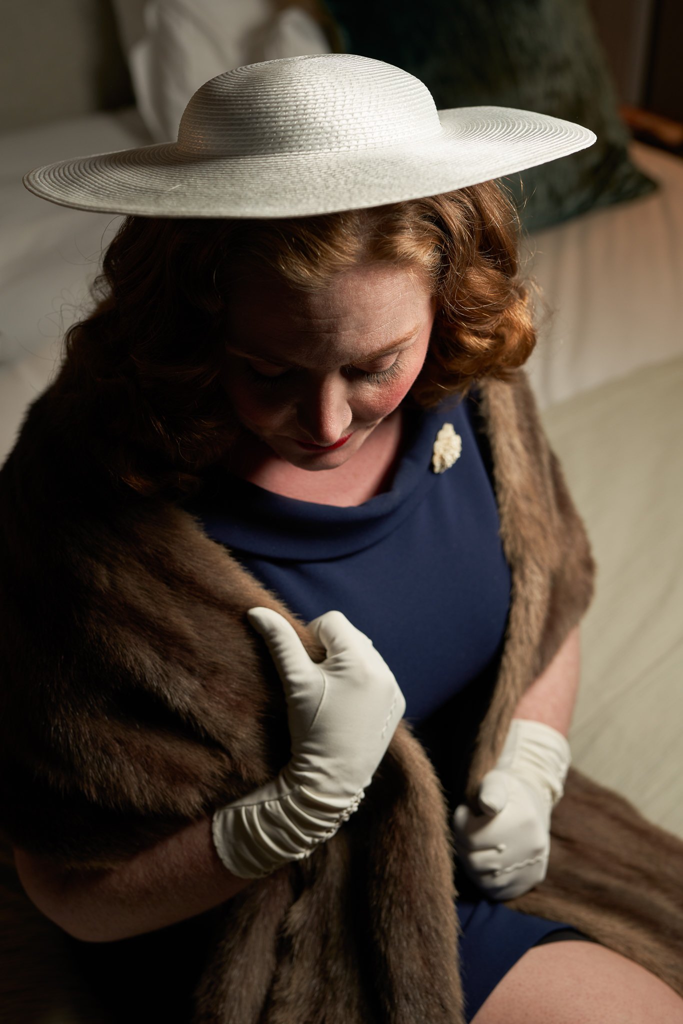 Laura in a wide-brimmed hat, fur stole and white gloves at the Fable