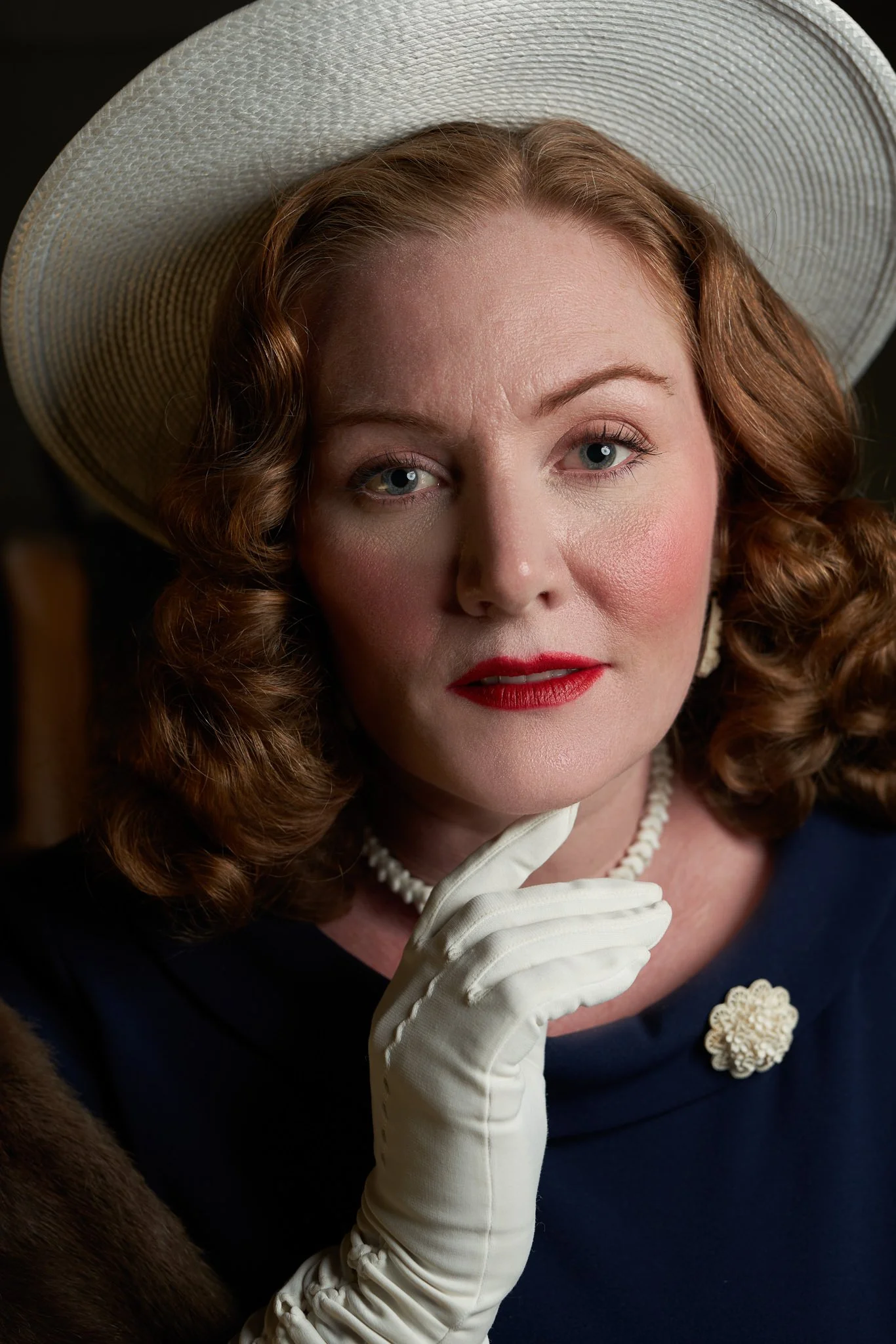 Laura with a gloved hand at her chin