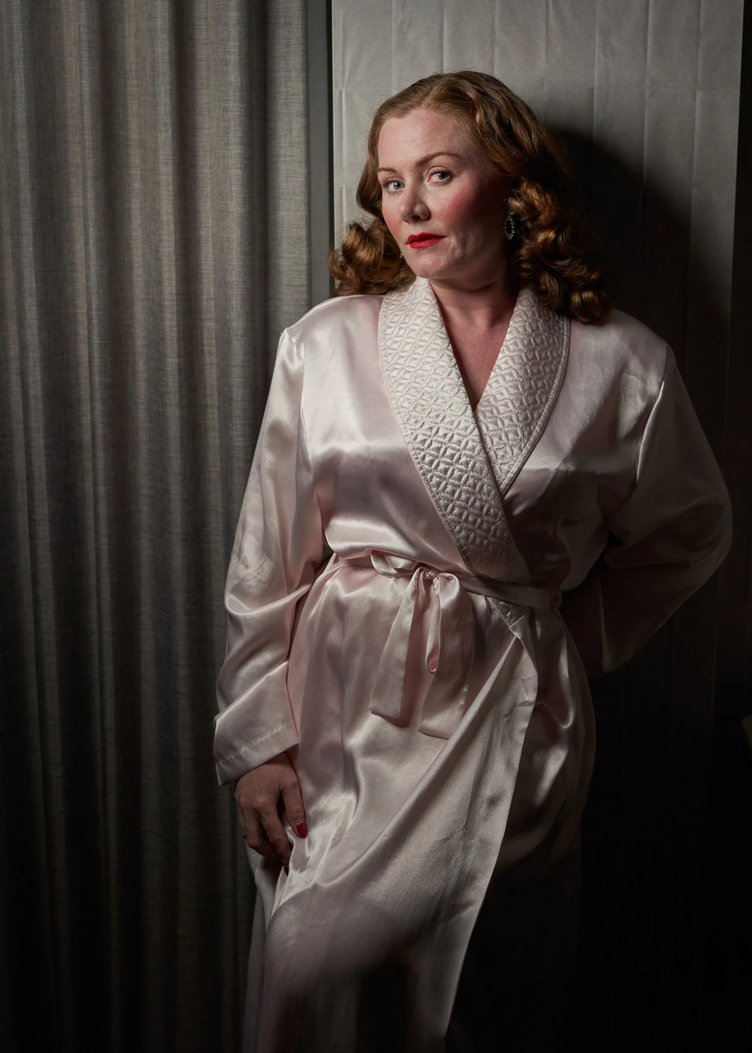 Laura in a satin robe with a hand on her hip