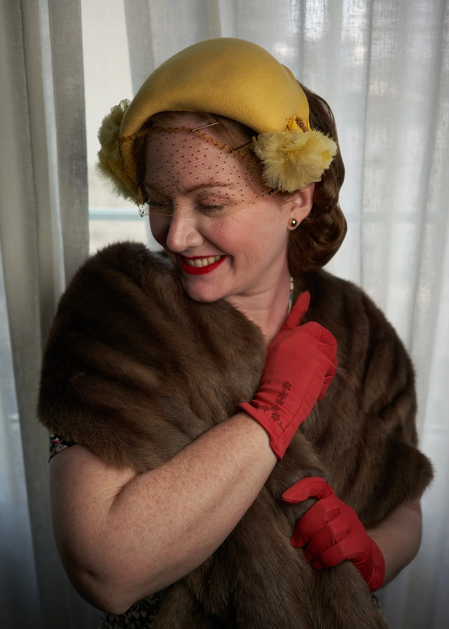 Laura smiles in a yellow hat and red gloves