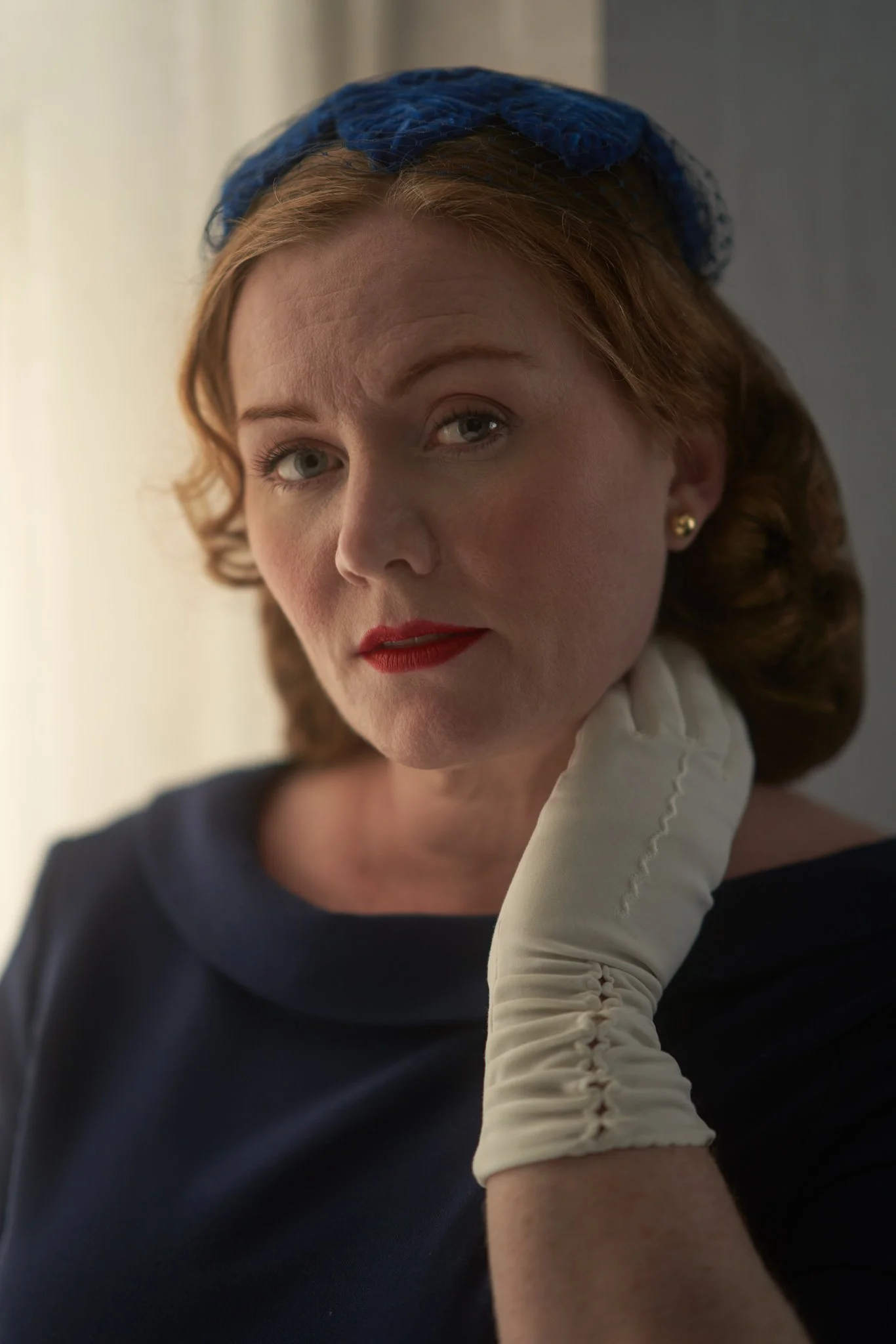 Laura with a gloved hand at her neck