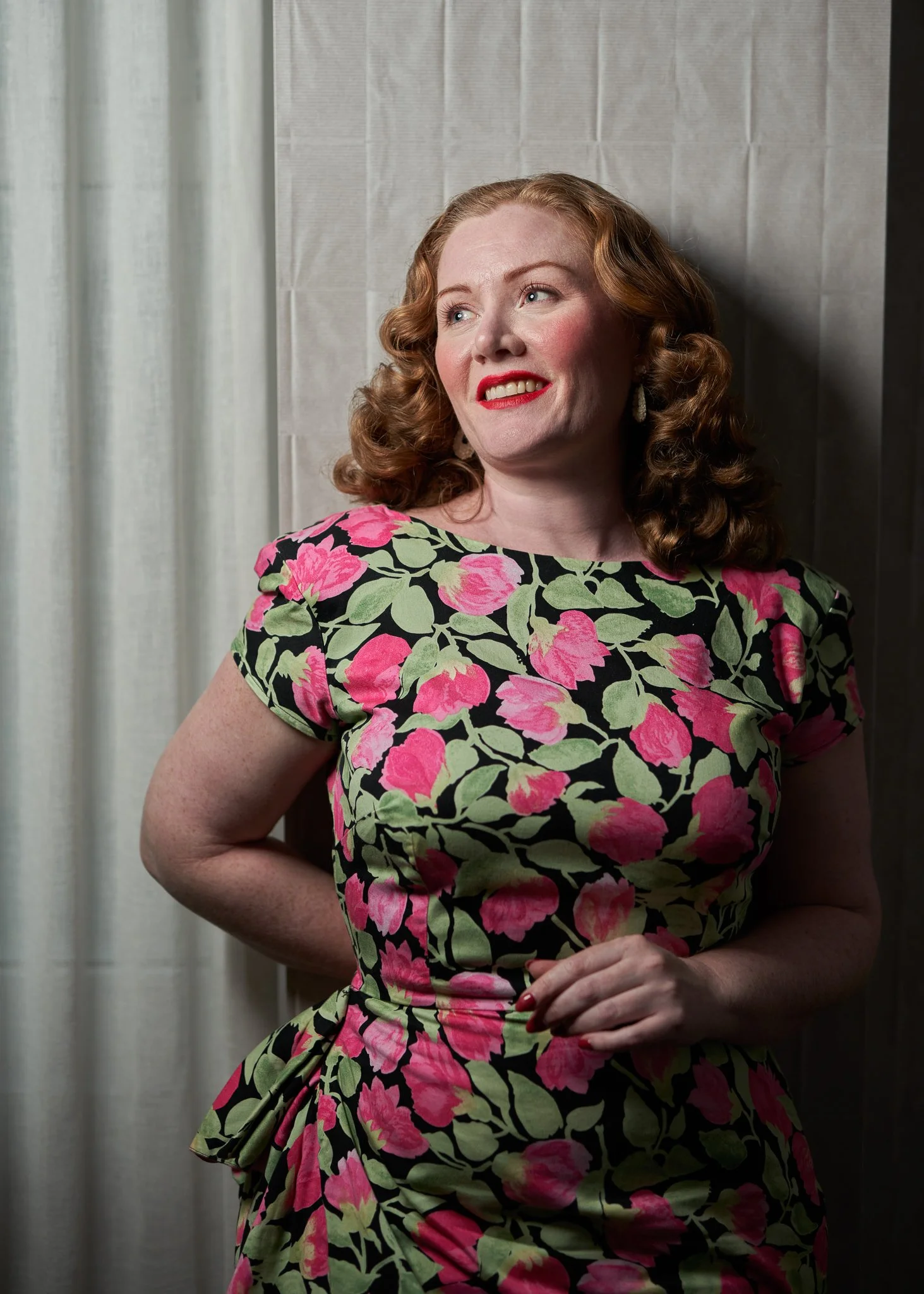 Laura smiles in a pink and green floral dress