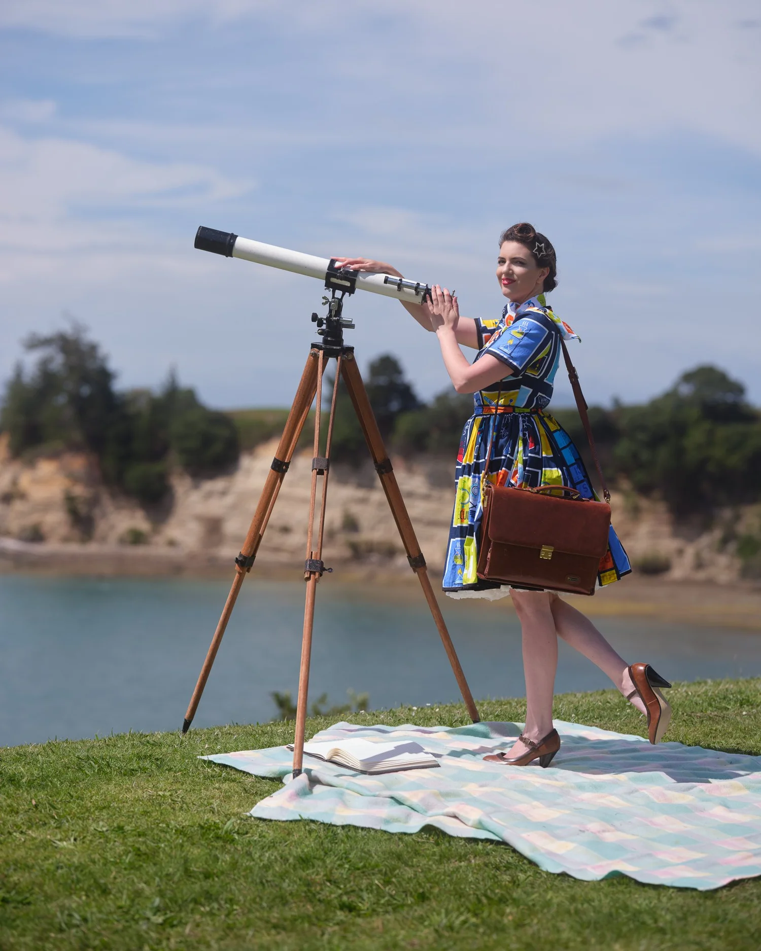 Jay at a telescope with a briefcase on the grass