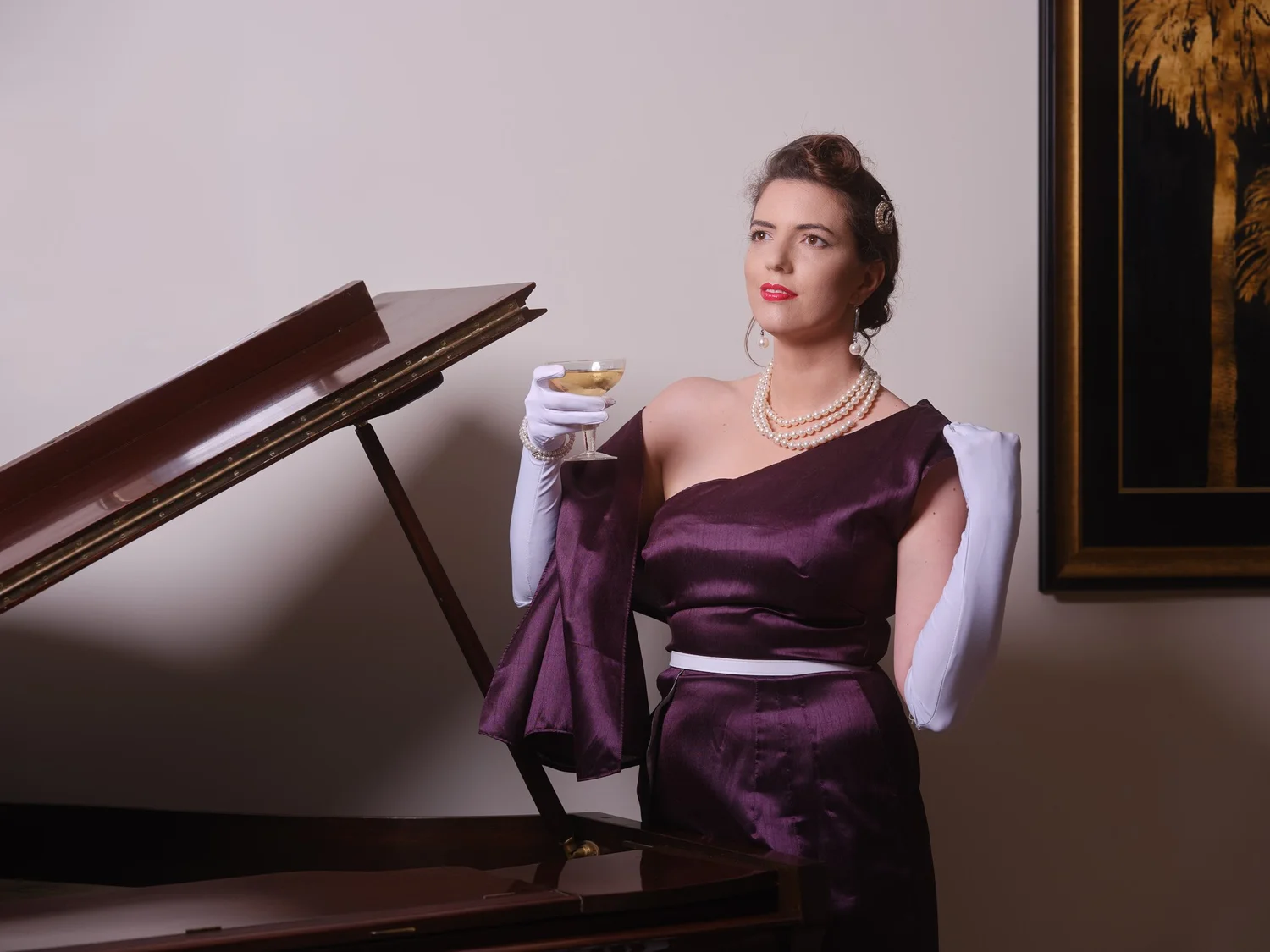 Jay in purple with a cocktail at the piano