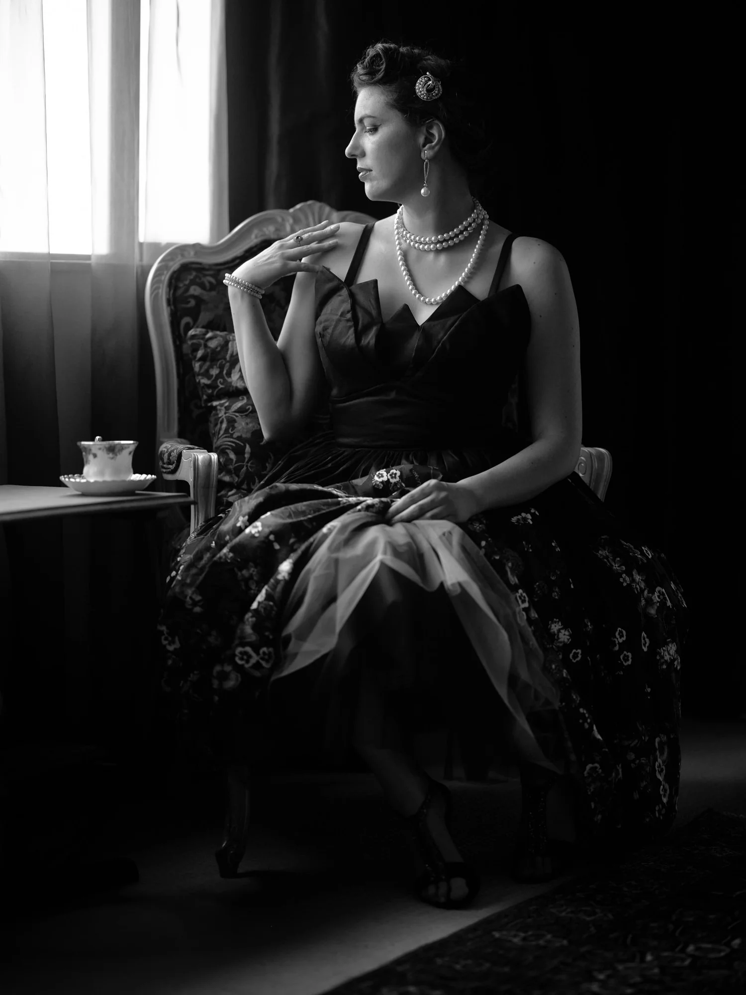 Black and white photo of Jay with a teacup by the window