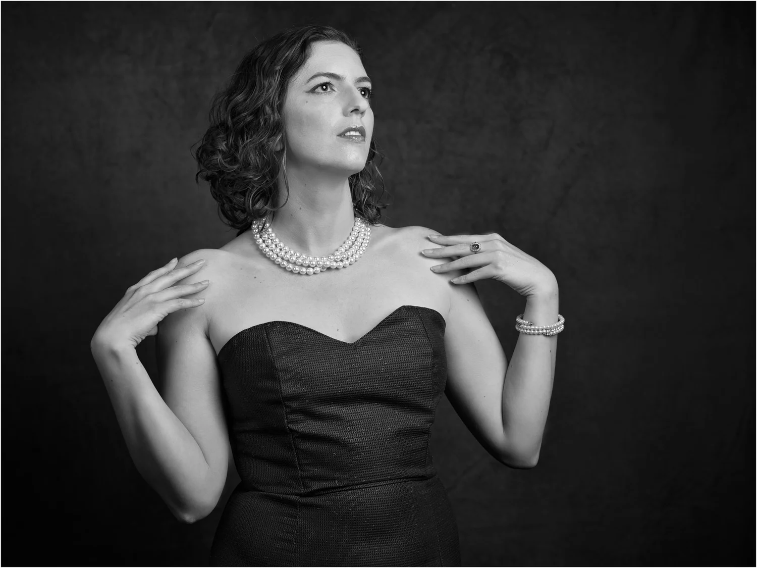 Black and white photo of Jay in a strapless dress and pearls