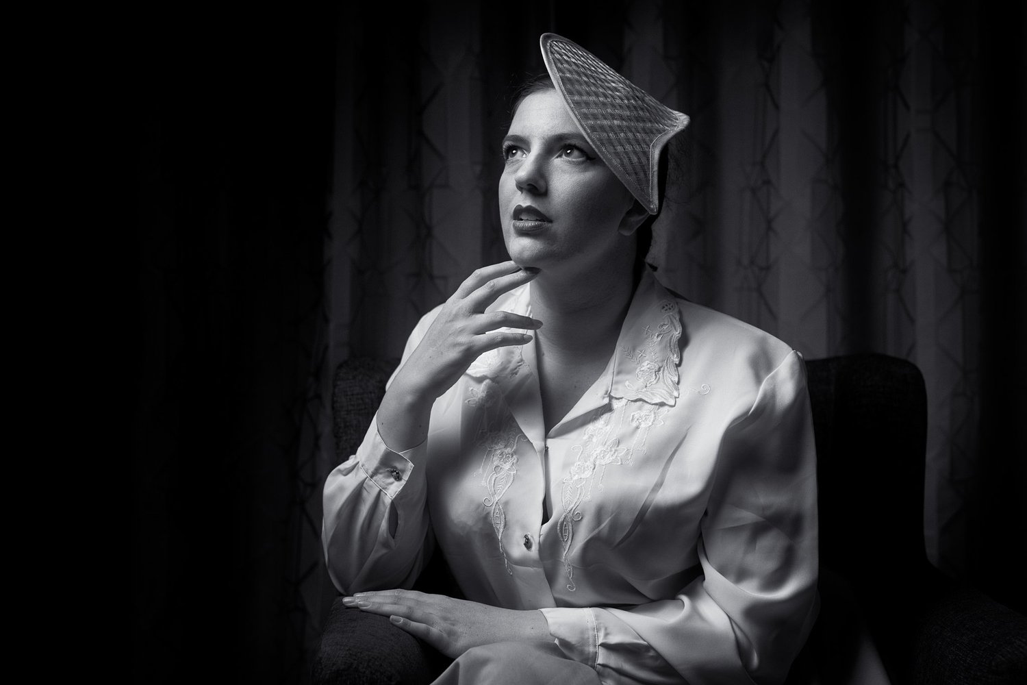 Black and white photo of Jay in a vintage hat looking upwards