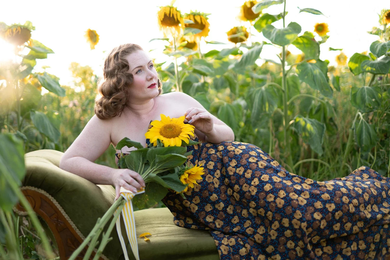 A model on a vintage sofa holding a sunflower