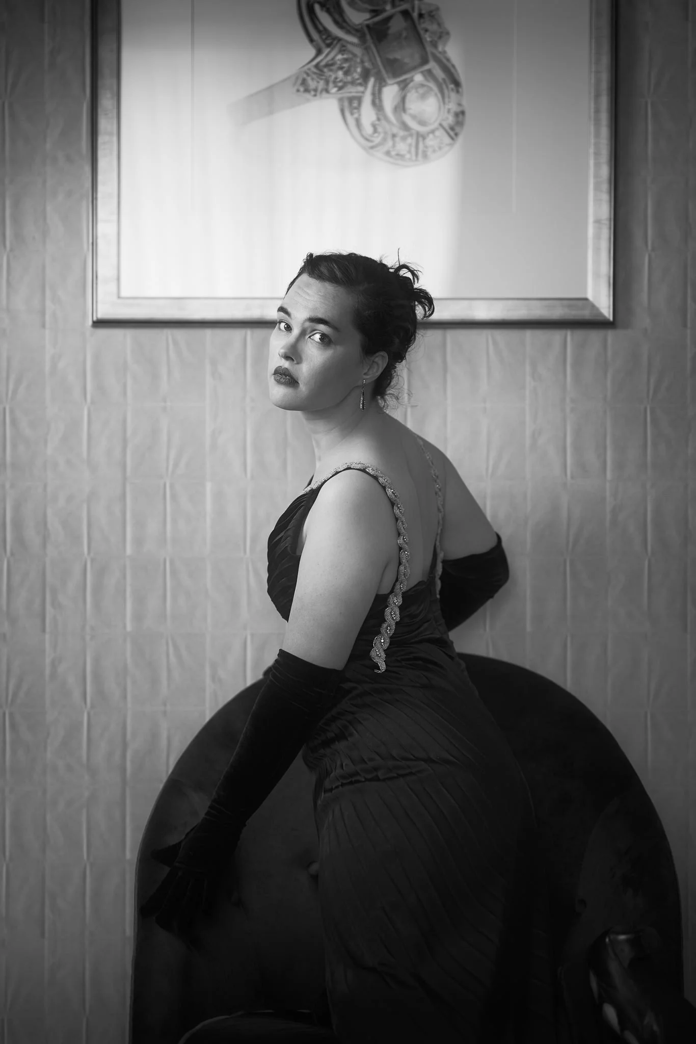 Black and white photo of Anita in a full black gown seen from behind