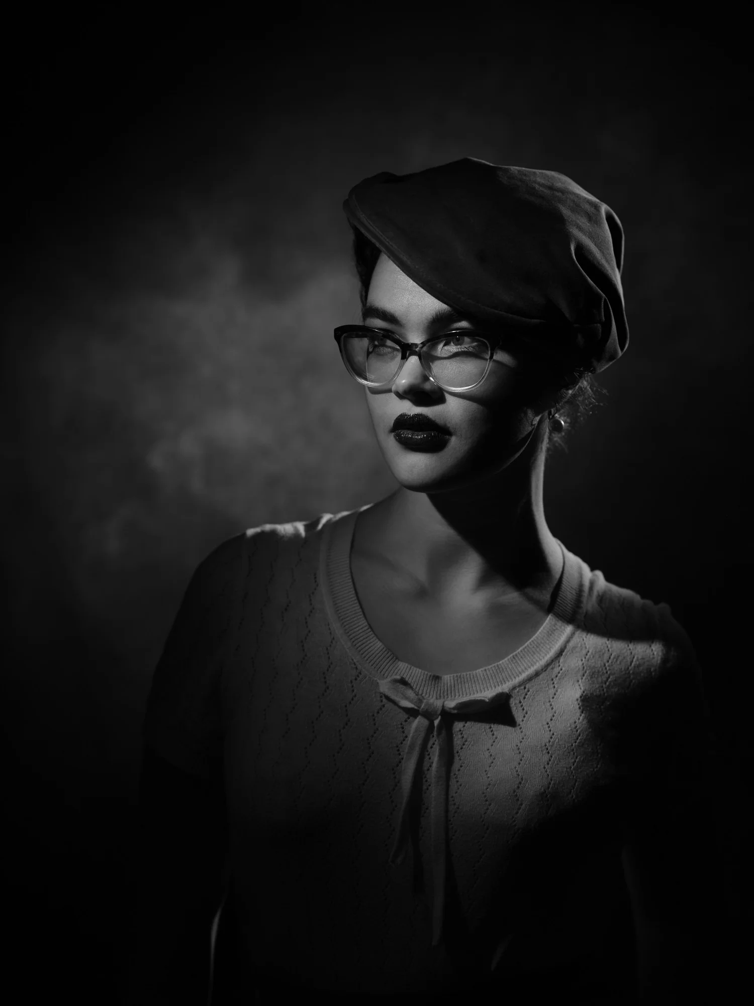 Black and white portrait of Anita in a beret and cat-eye glasses
