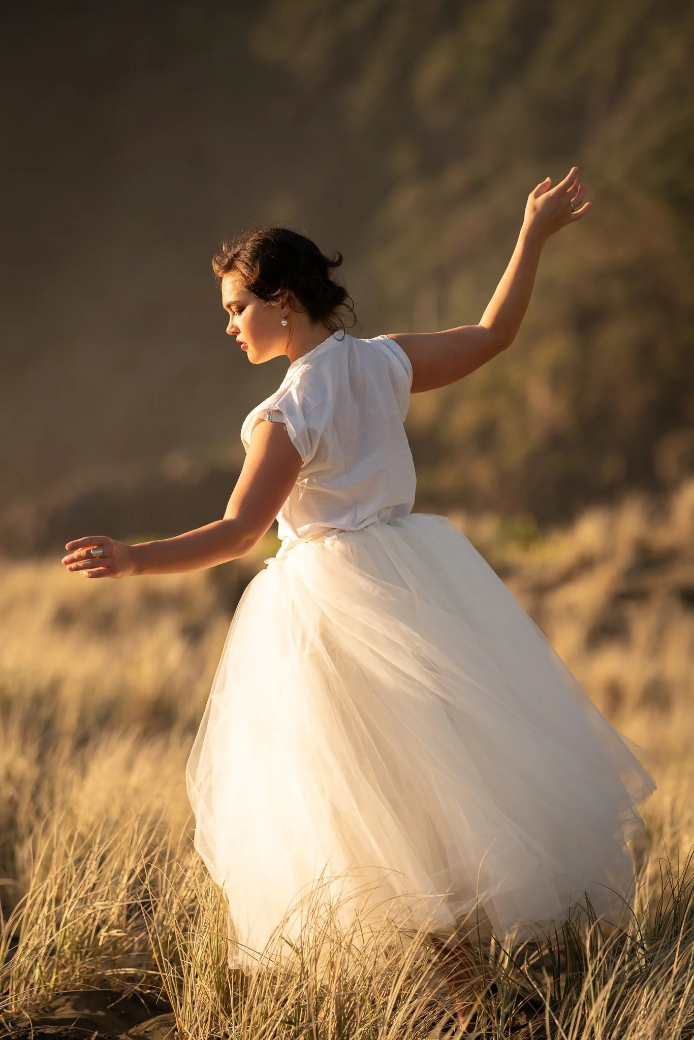 Anita dances in a white tulle skirt through golden grass