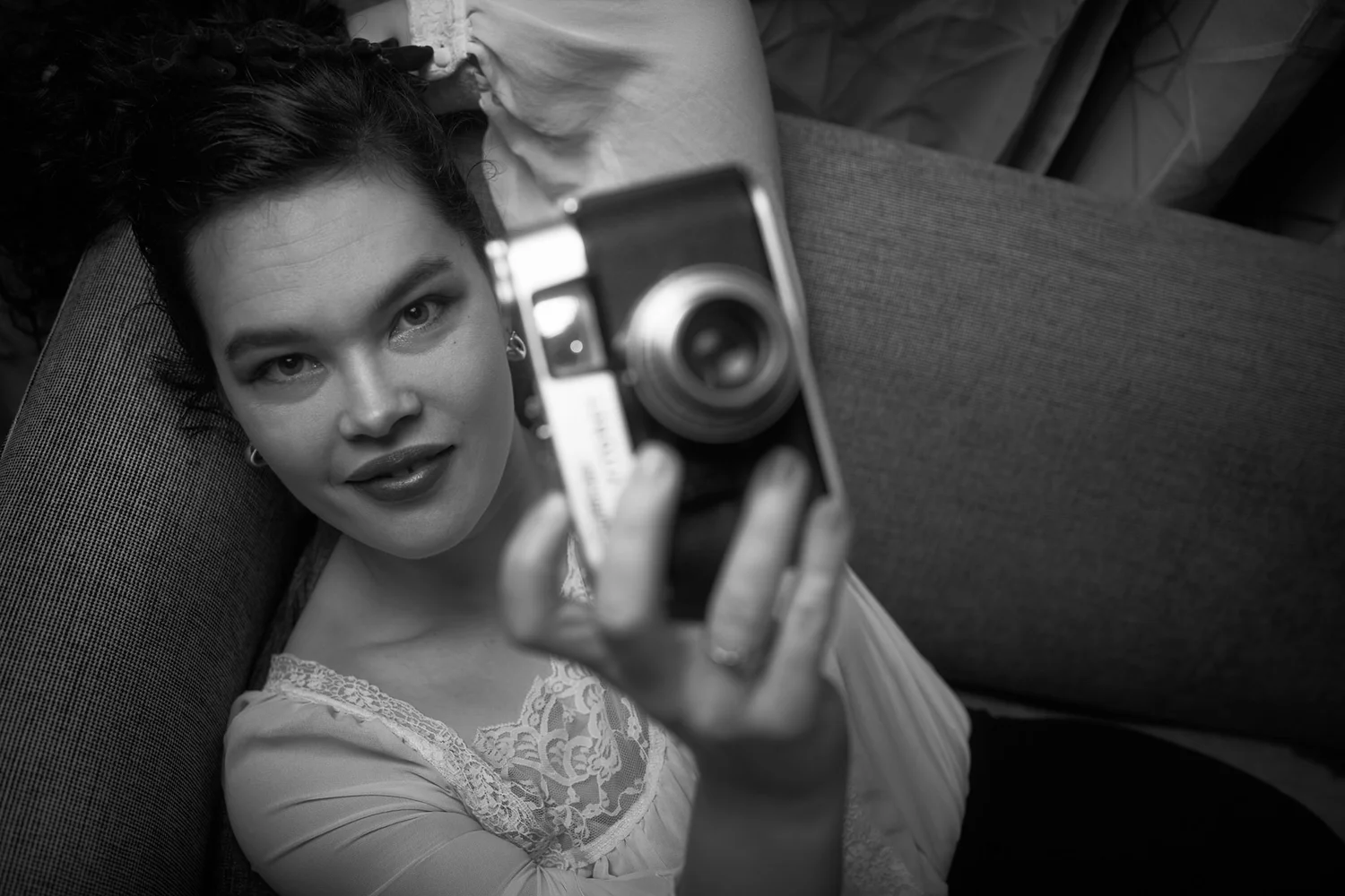 Black and white photo of Anita holding up a vintage camera