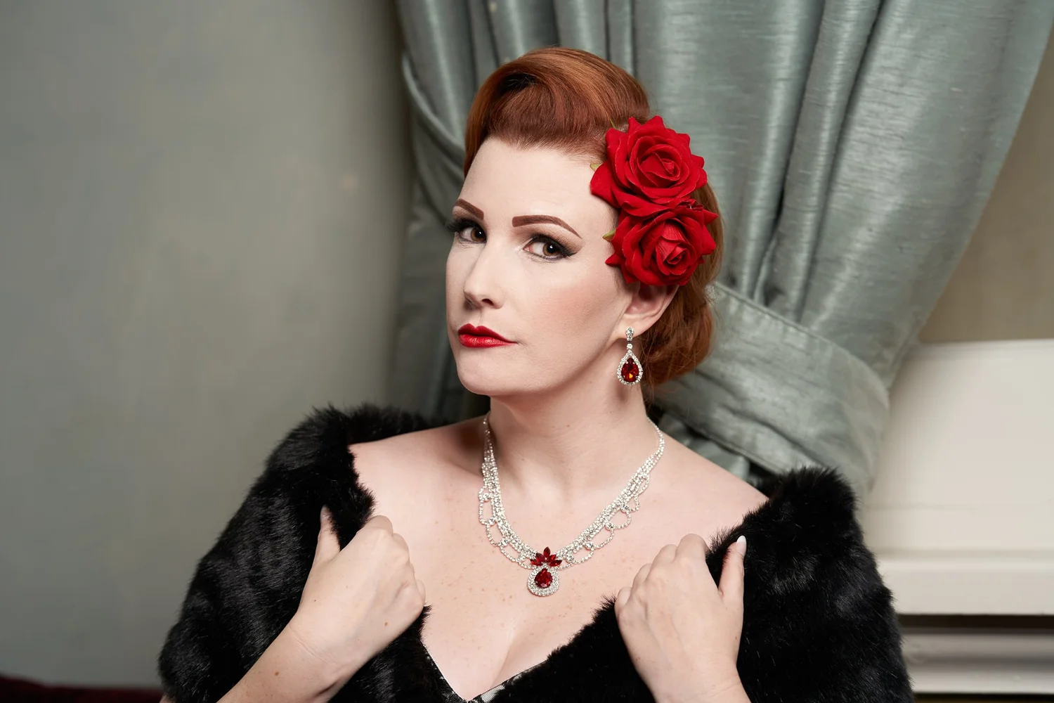 Jasmine in a fur stole with a red flower in her hair