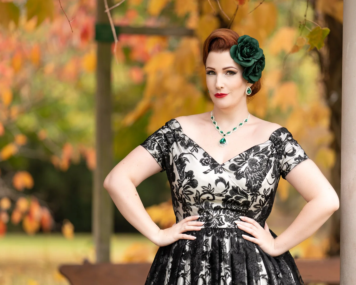 Jasmine poses with hands on hips in an autumn garden