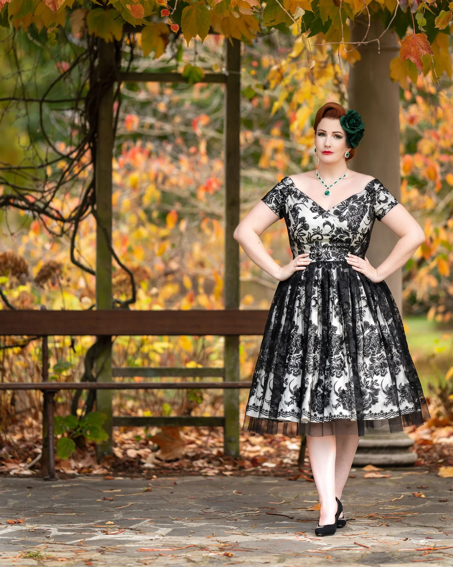 Full-length photo of Jasmine in a lace dress under an autumn pergola