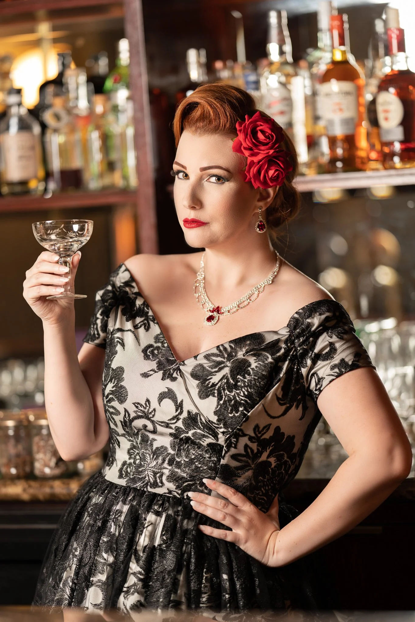 Jasmine raises her glass in front of the bar shelves
