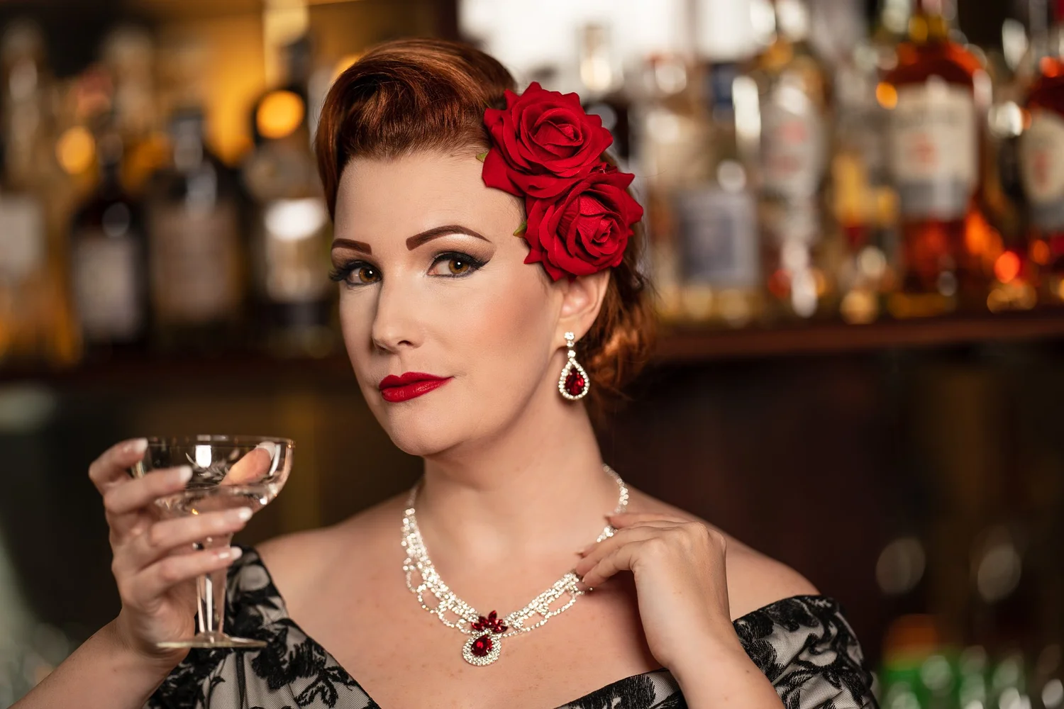 Close portrait of Jasmine with a glass in warm bar light
