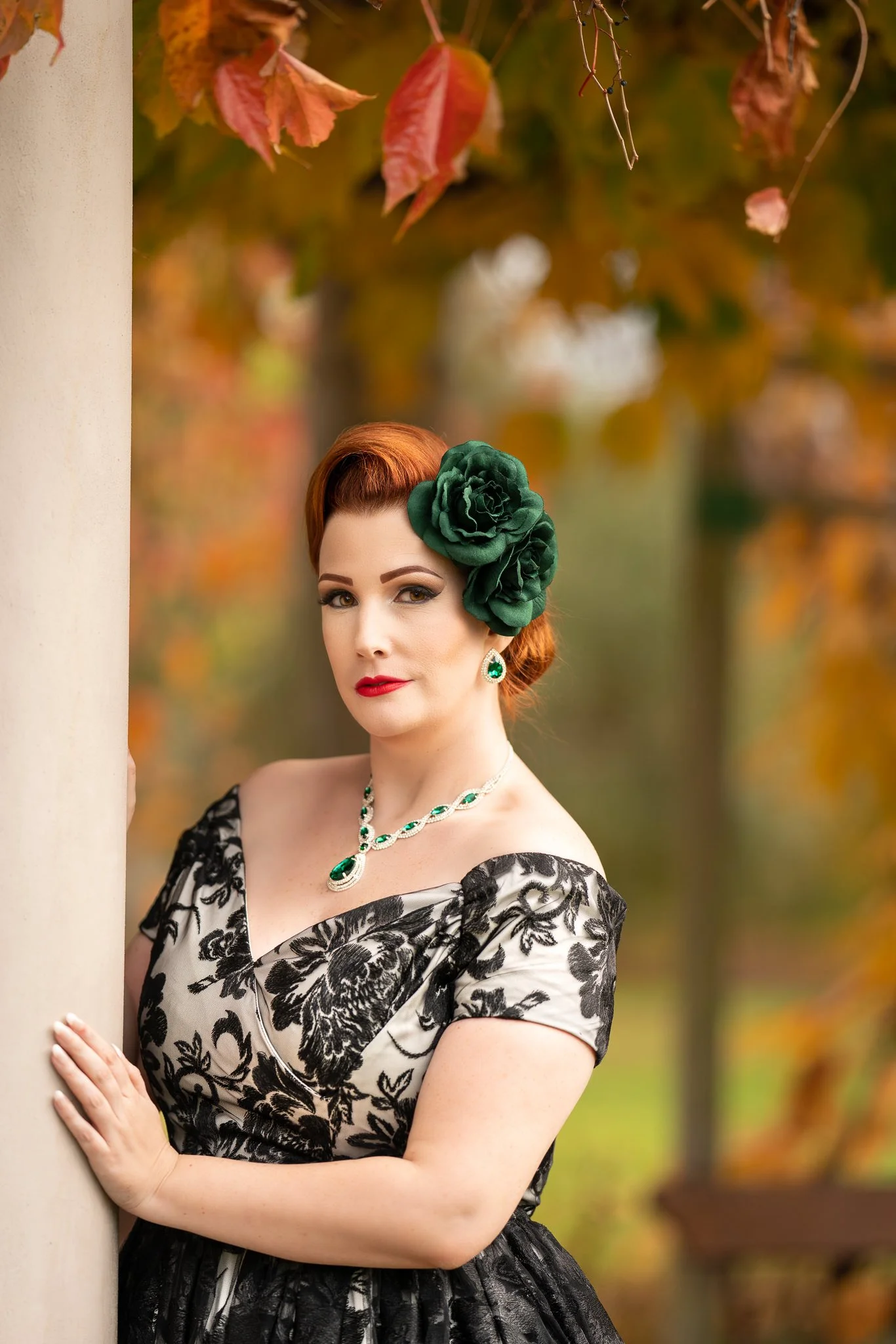 Jasmine leans against a pillar among autumn foliage