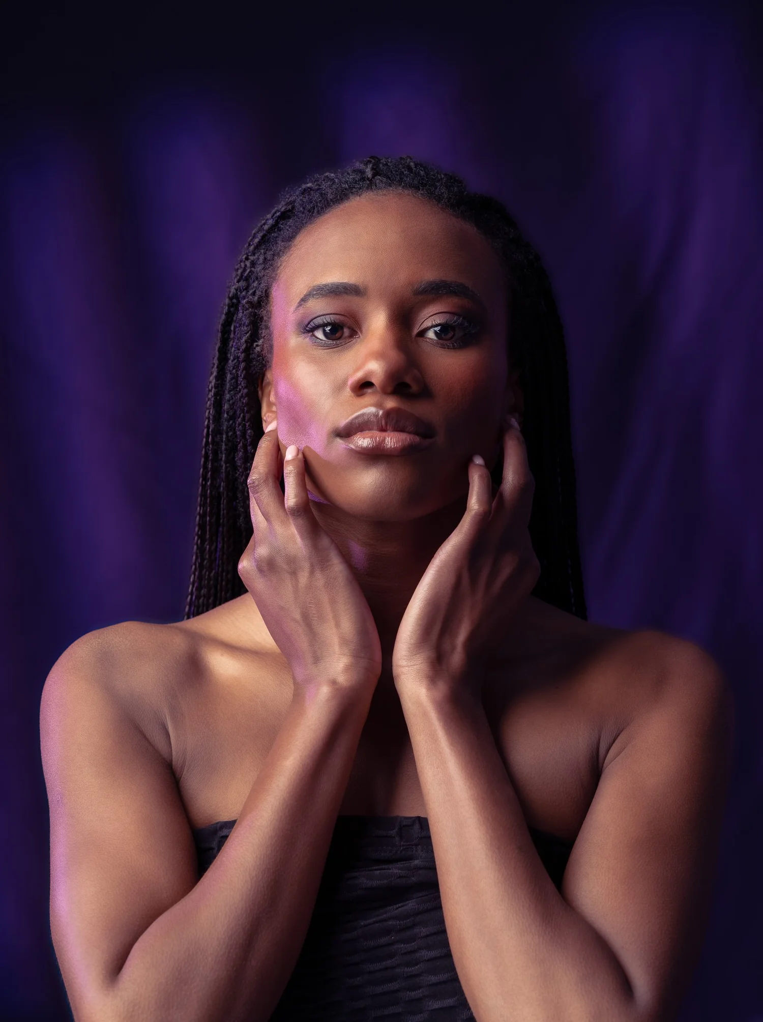 Ty holds her face in her hands in purple light