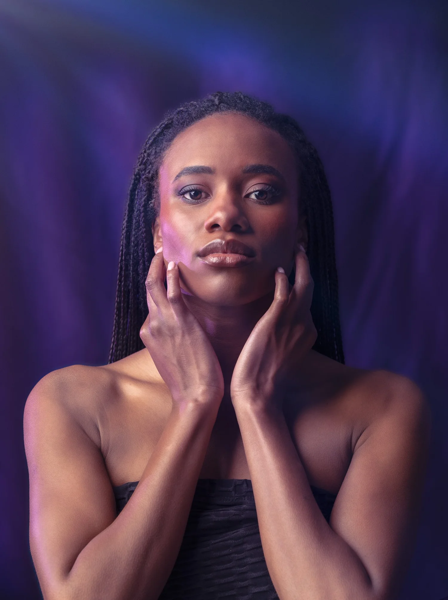 Ty with hands at her face under blue and purple light
