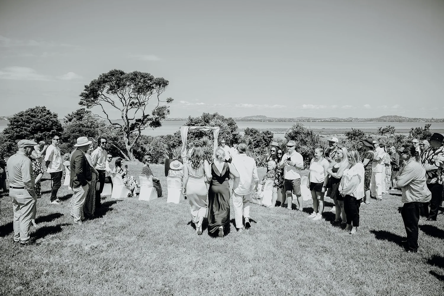 Black and white photo of guests gathered for the waterside ceremony