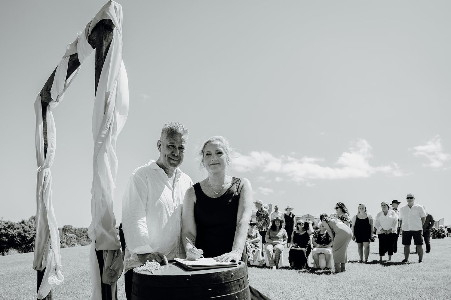 Black and white photo of Raewyn and Shane signing the register