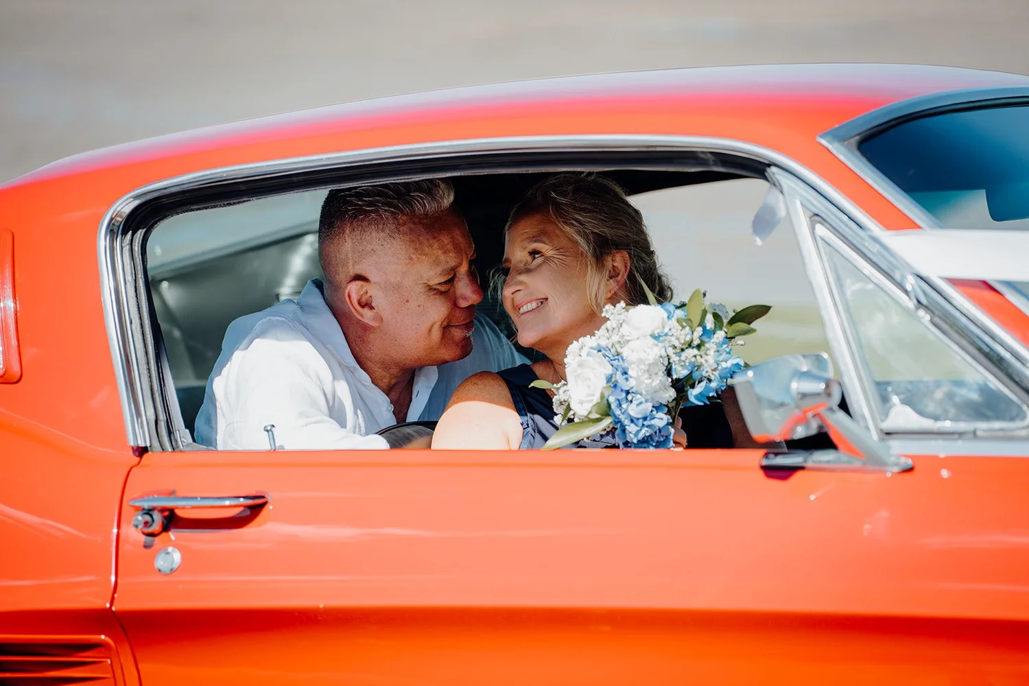 Raewyn and Shane in a red classic car