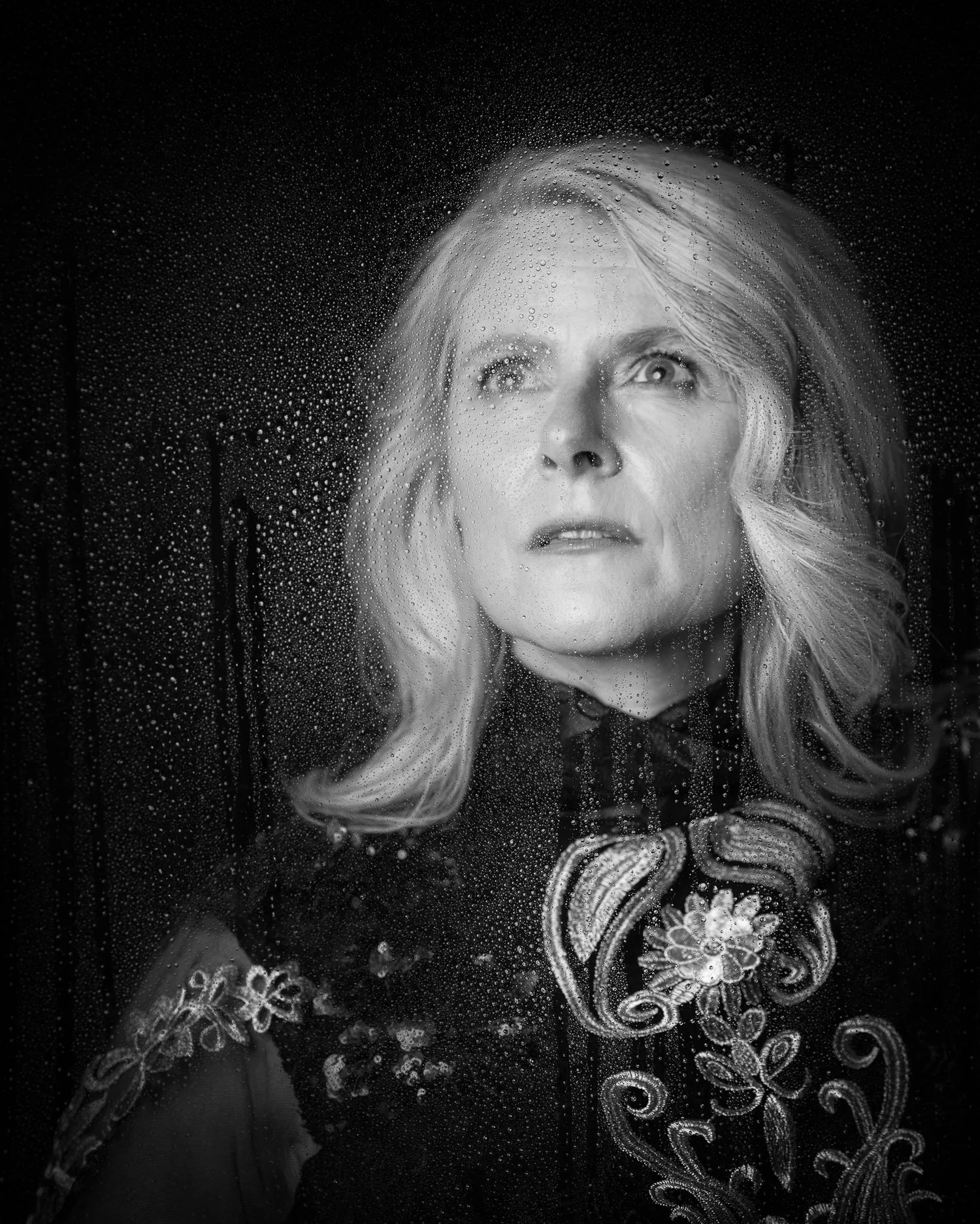 Black and white portrait of Ivanka through rain-speckled glass