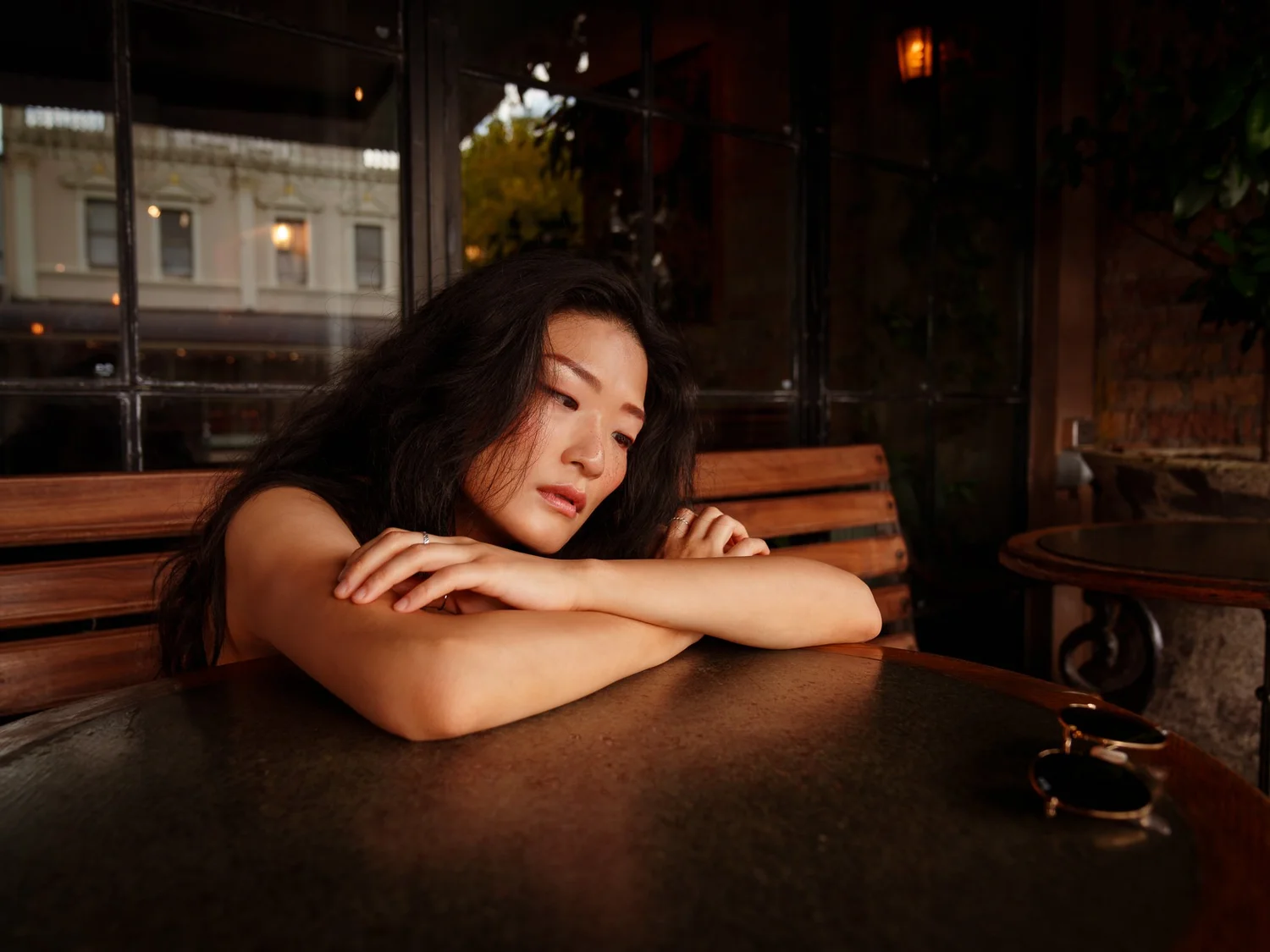 Anna rests her arms on a café table during a Ponsonby street shoot