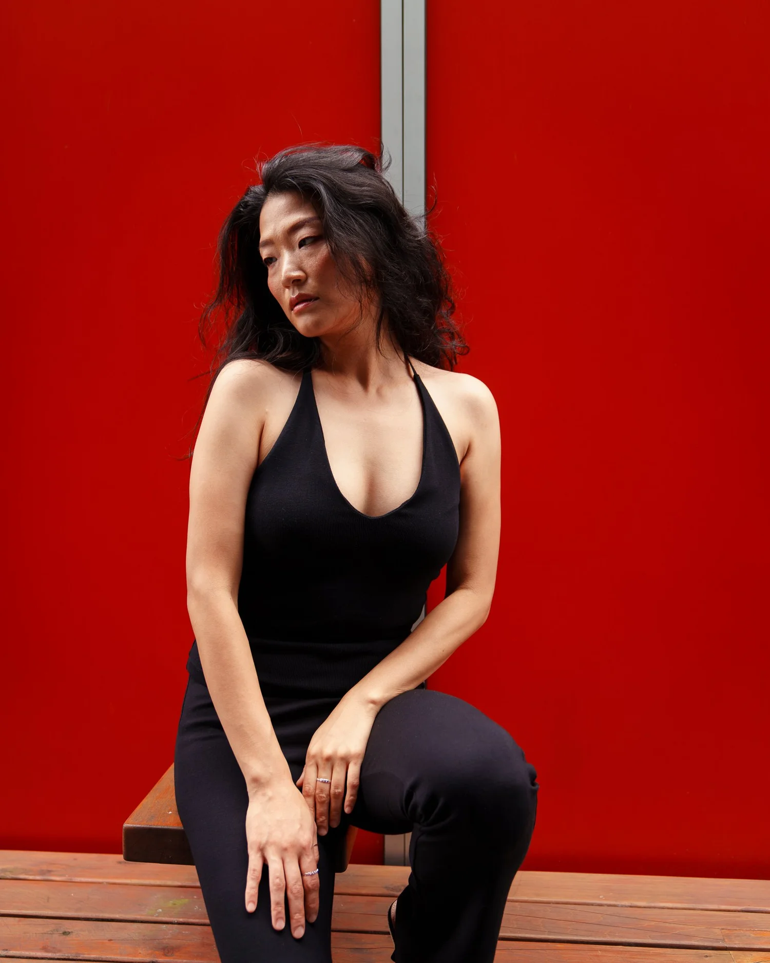 Anna seated in front of a bright red door