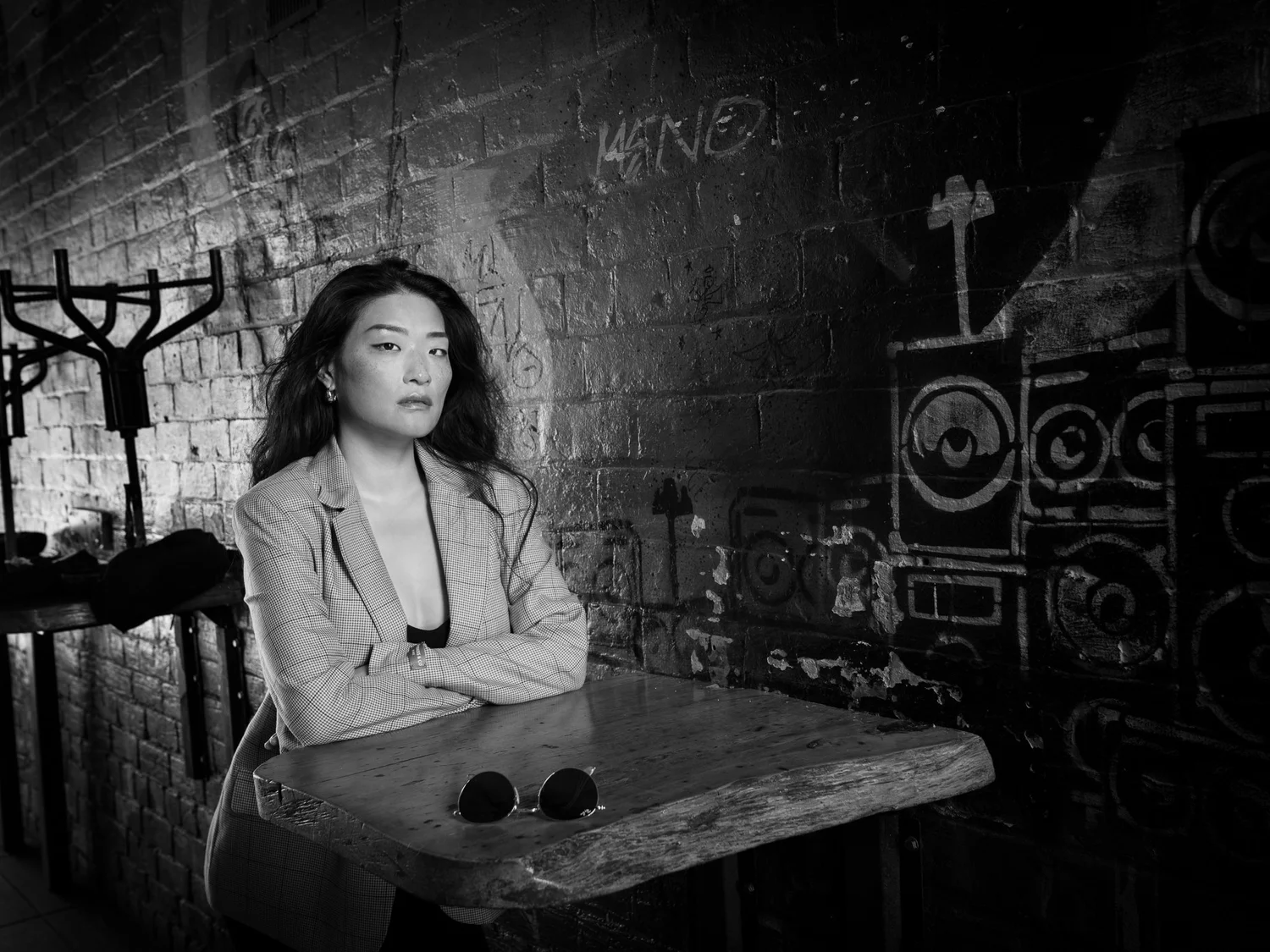Black and white photo of Anna in a blazer at a courtyard table
