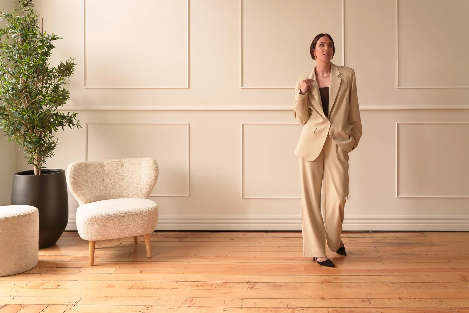 Nat in a cream suit in a bright styled room