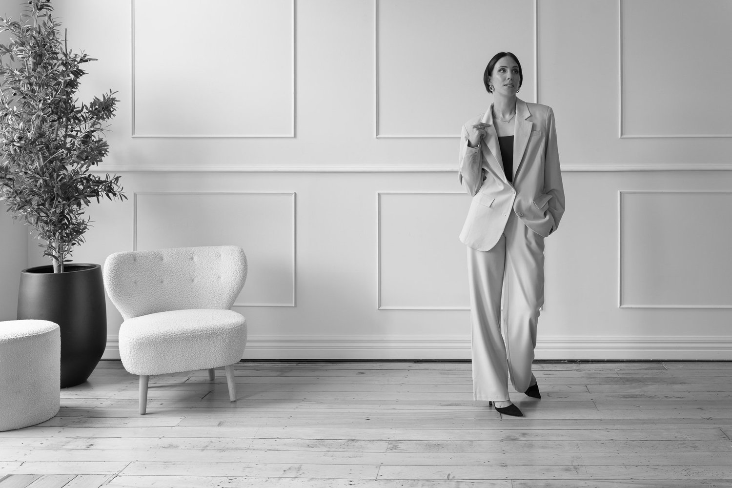 Black and white photo of Nat standing in a styled room