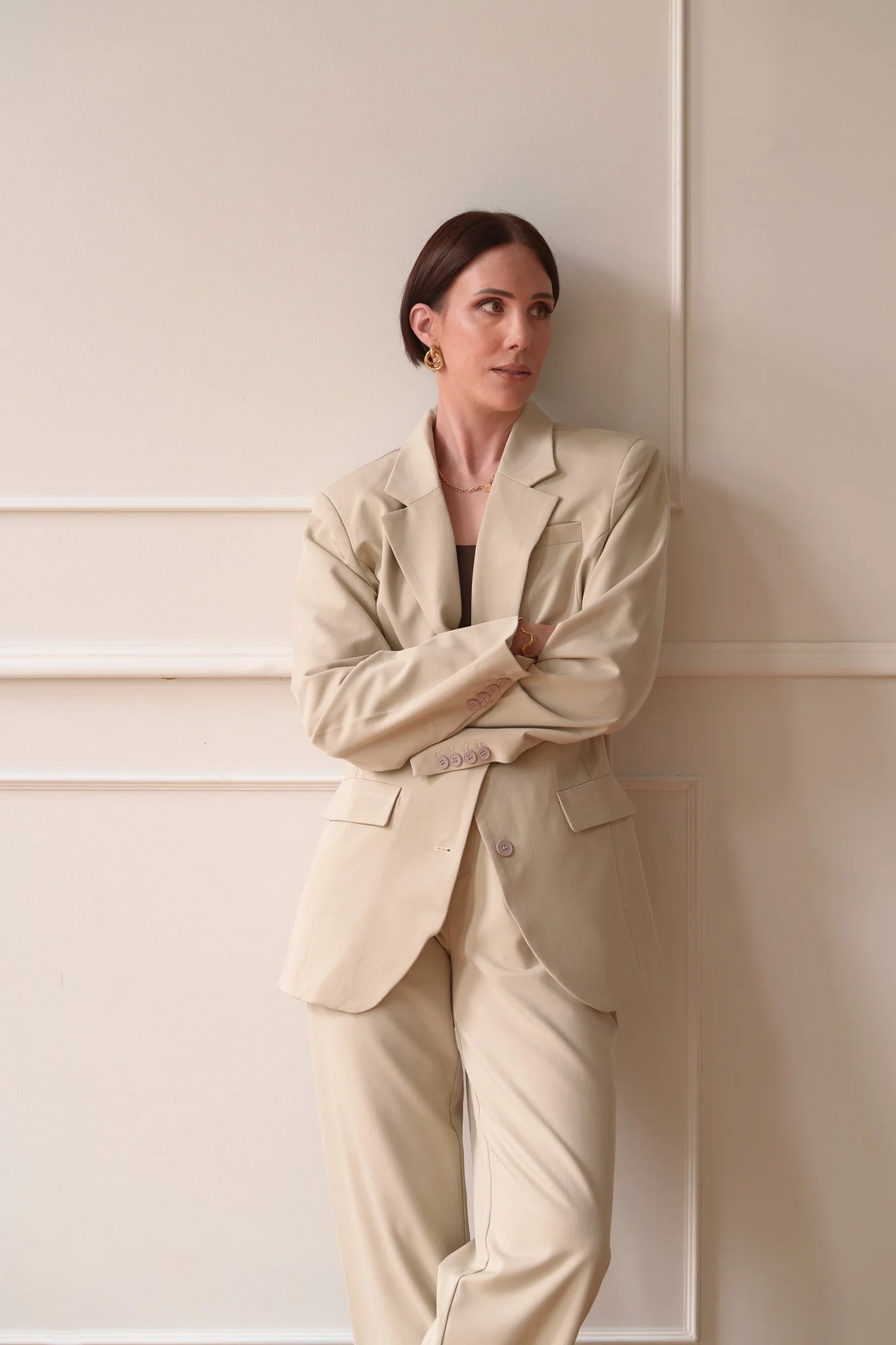 Nat with folded arms against a panelled wall