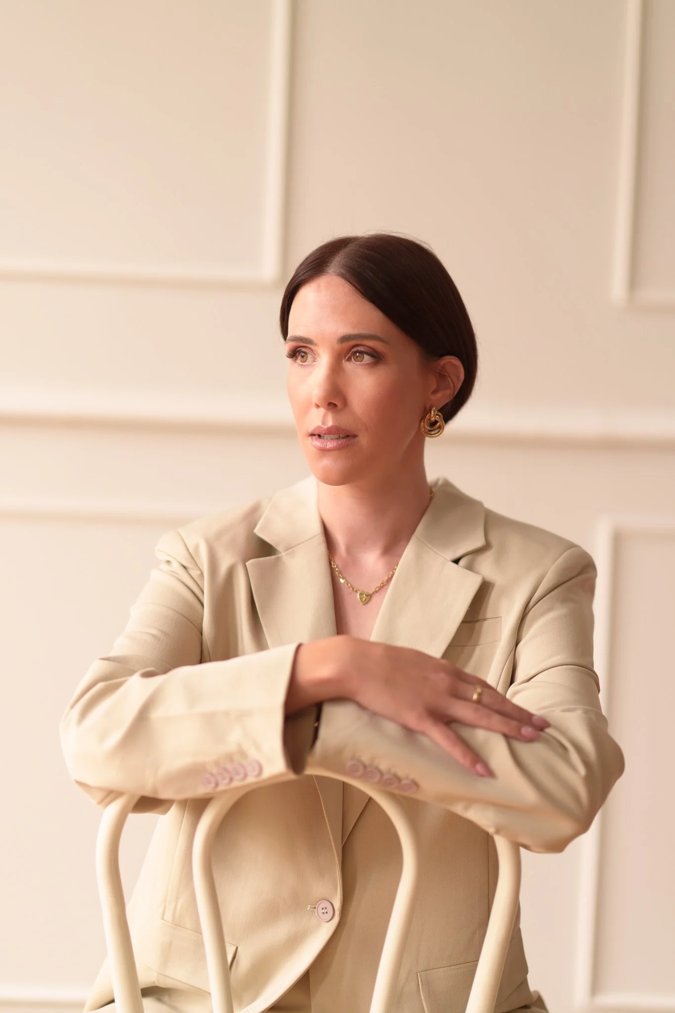 Nat leans on the back of a bentwood chair