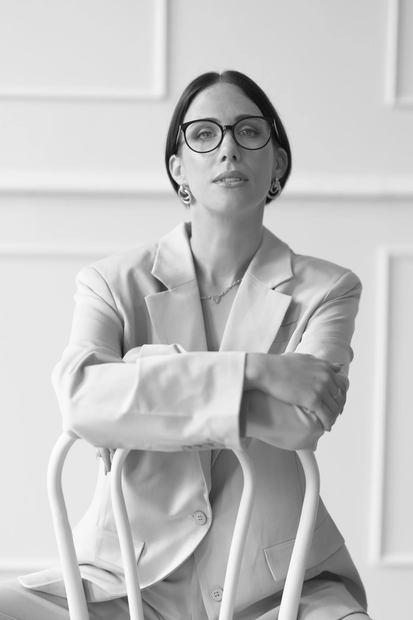Black and white photo of Nat in glasses over a chair back