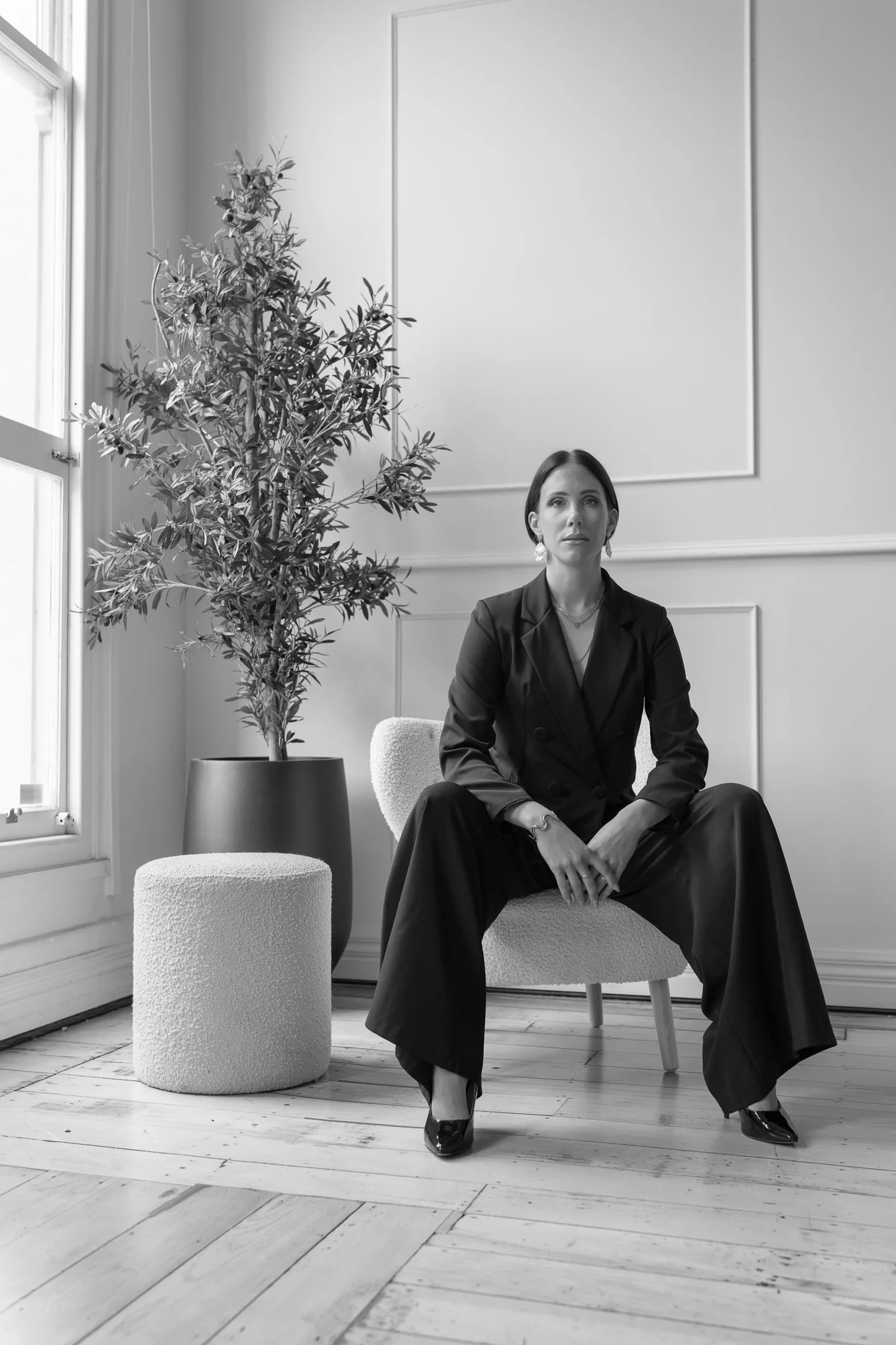 Black and white photo of Nat seated in a black suit