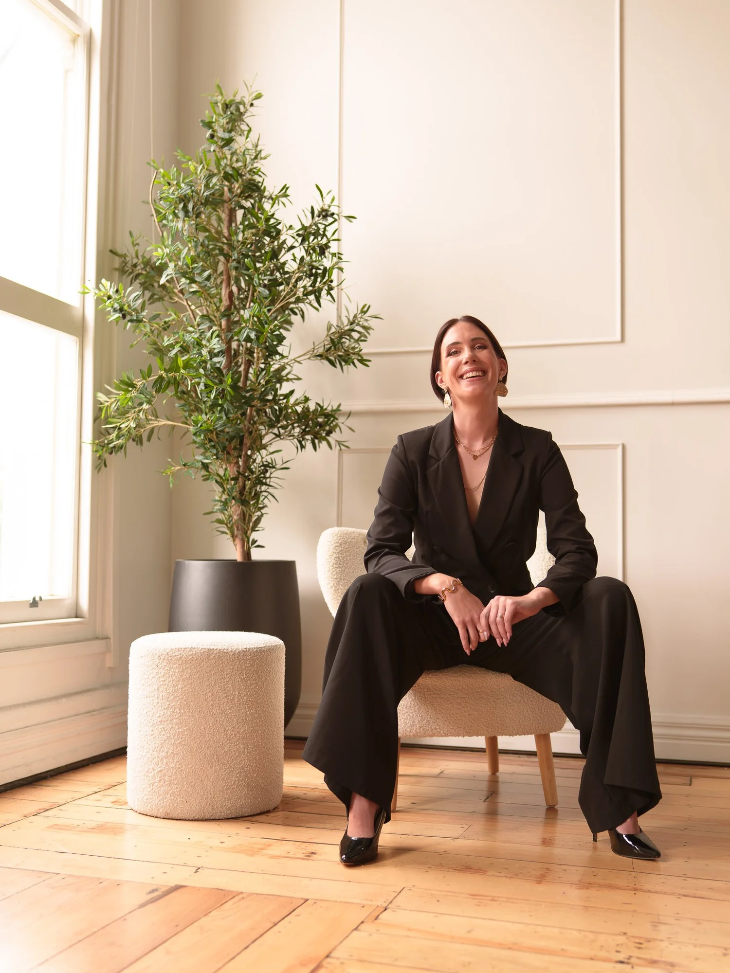 Nat laughs seated in a black suit