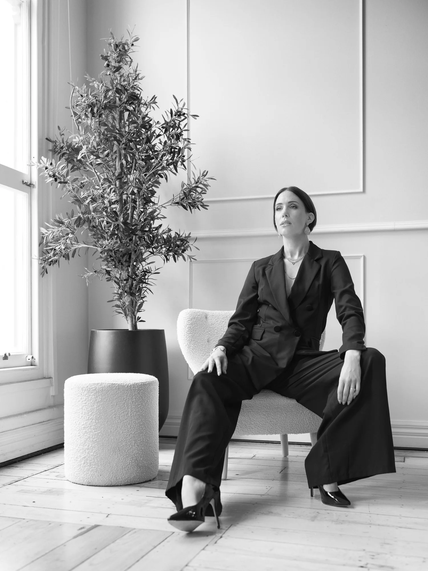 Black and white photo of Nat with legs crossed