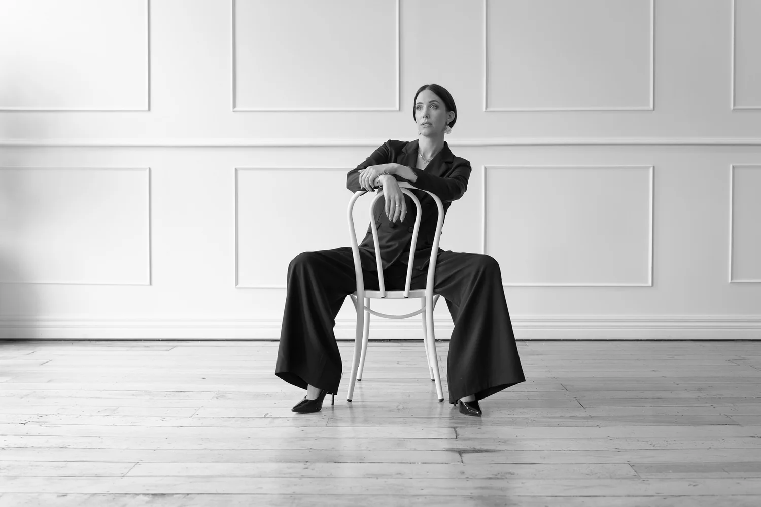 Black and white photo of Nat sitting astride a chair