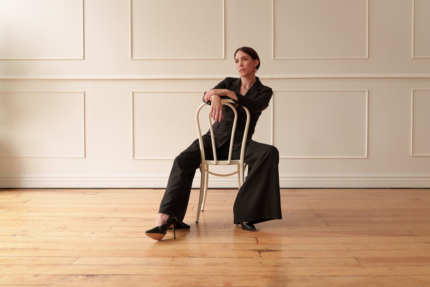 Nat sits astride a chair in warm light