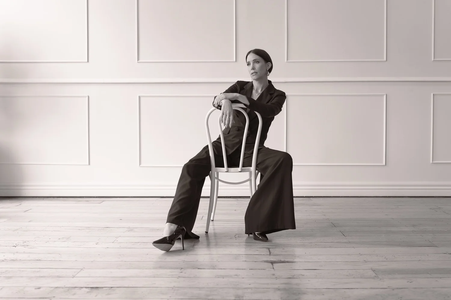 Black and white photo of Nat leaning on a chair back
