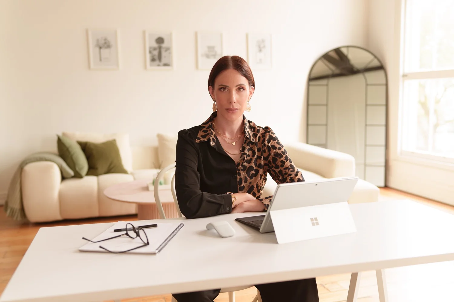 Nat working at a white desk with a laptop