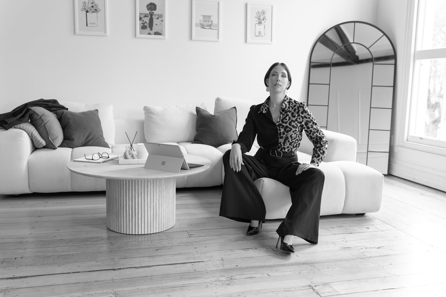 Black and white photo of Nat seated on a white sofa