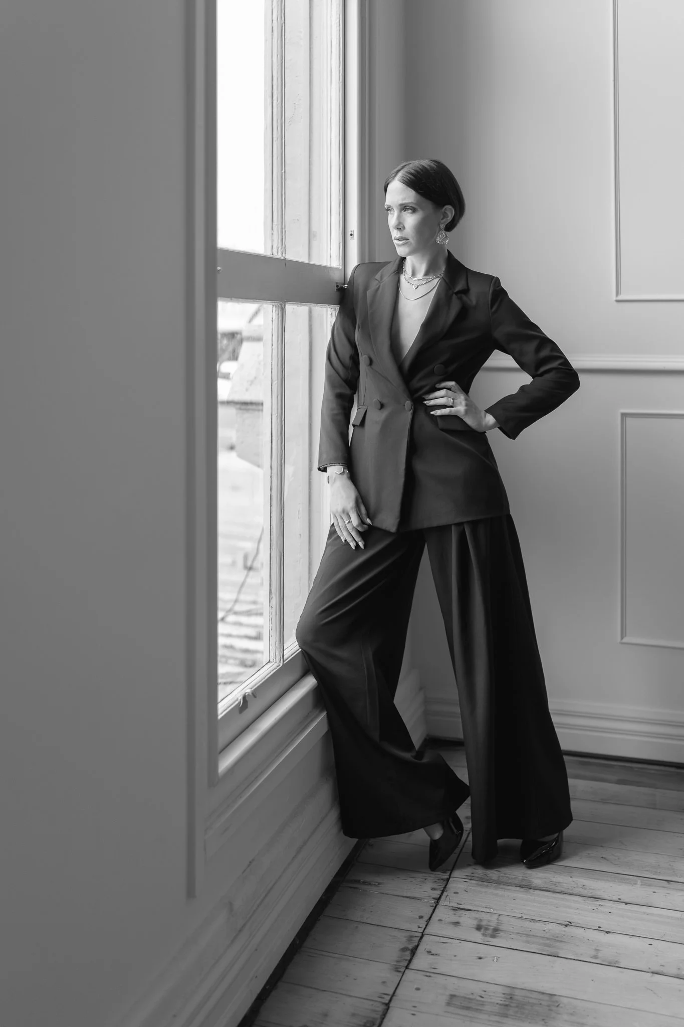 Black and white photo of Nat leaning by a window