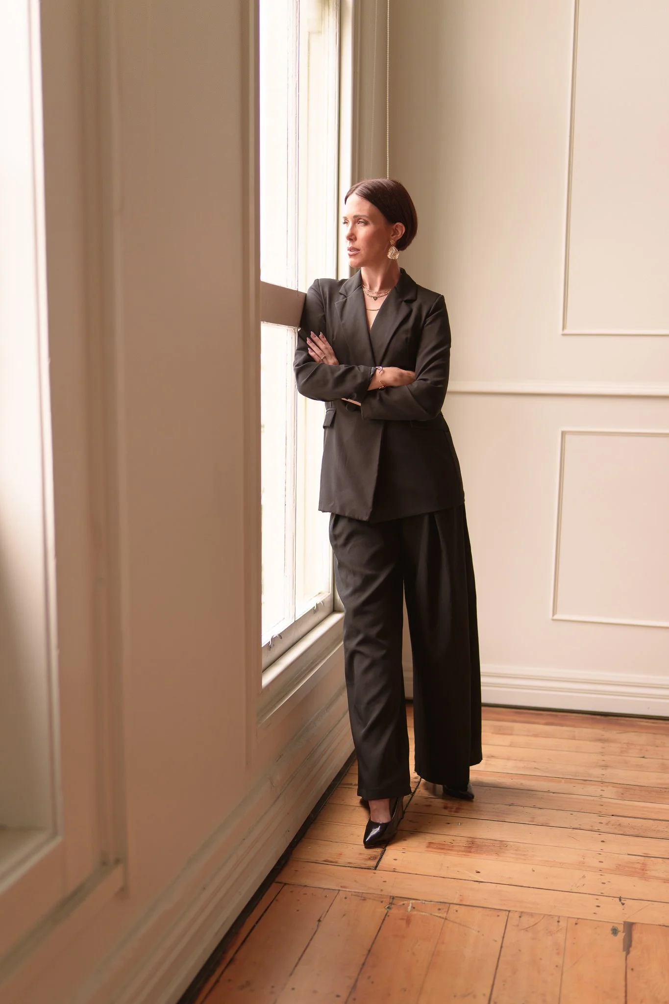 Nat with folded arms looking out of a window