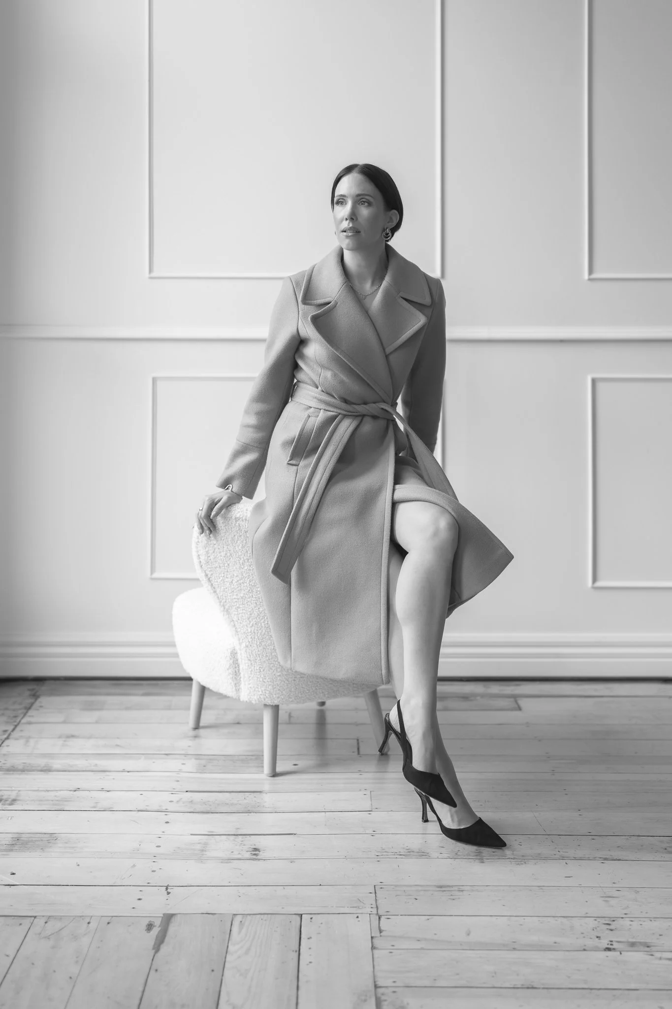 Black and white photo of Nat perched on a chair arm