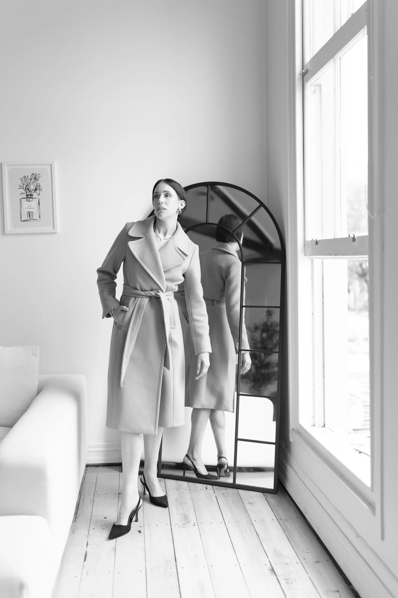 Black and white photo of Nat beside an arched mirror