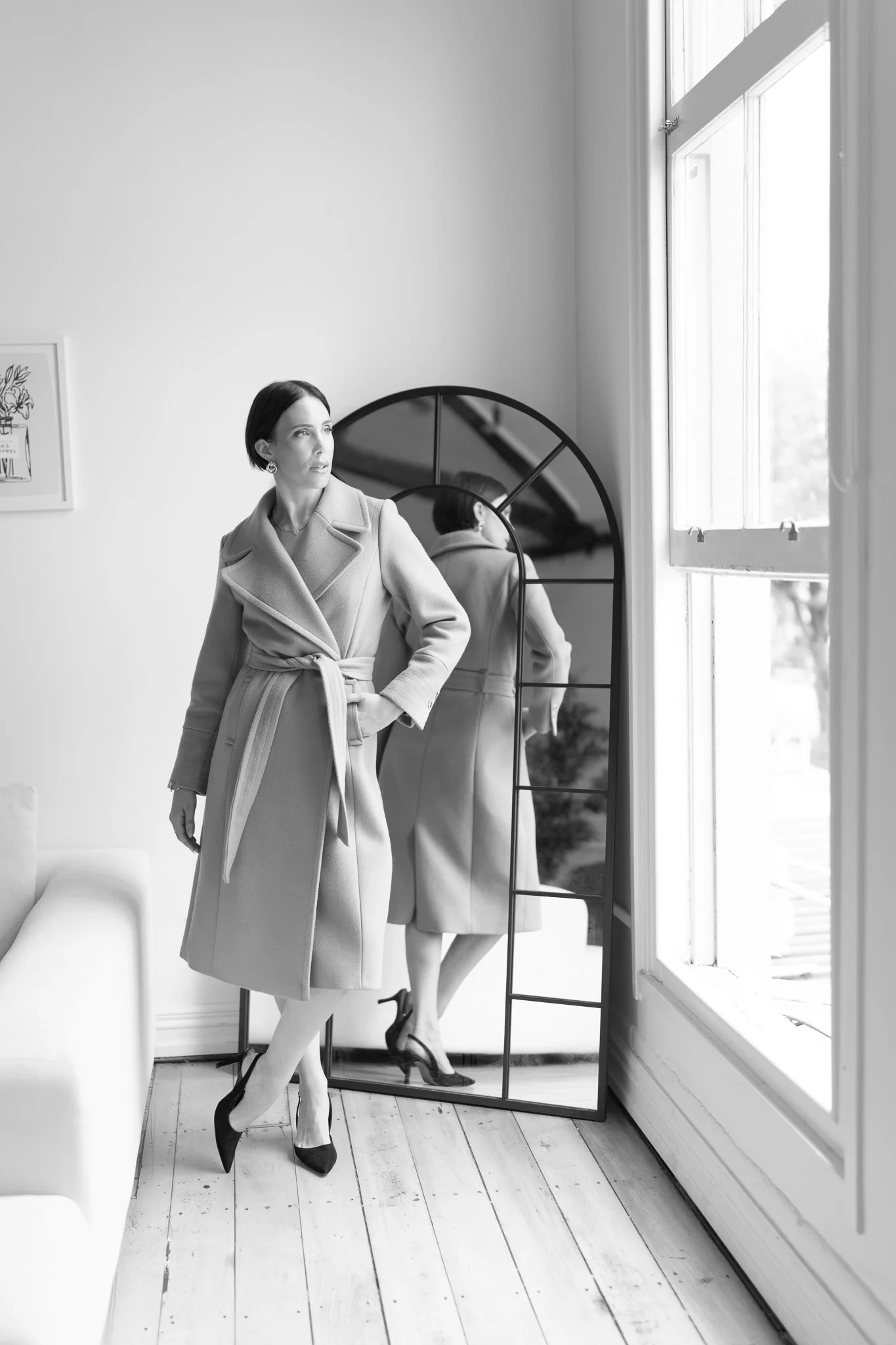Black and white photo of Nat by the window and mirror
